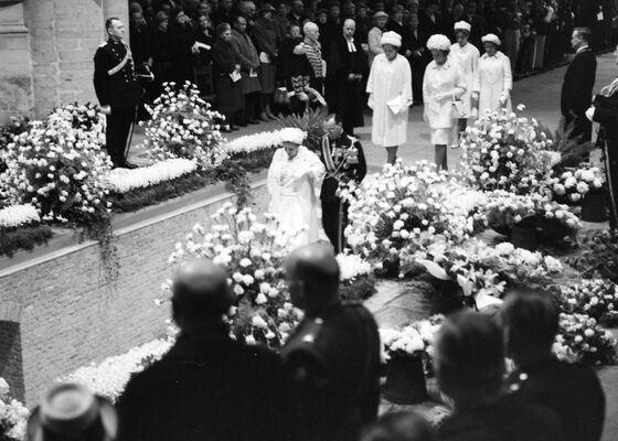 Uitvaart prinses Wilhelmina , Koningin Juliana en prins Bernhard gaan in de Nieuwe Kerk de grafkelder in, daarachter de prinsessen